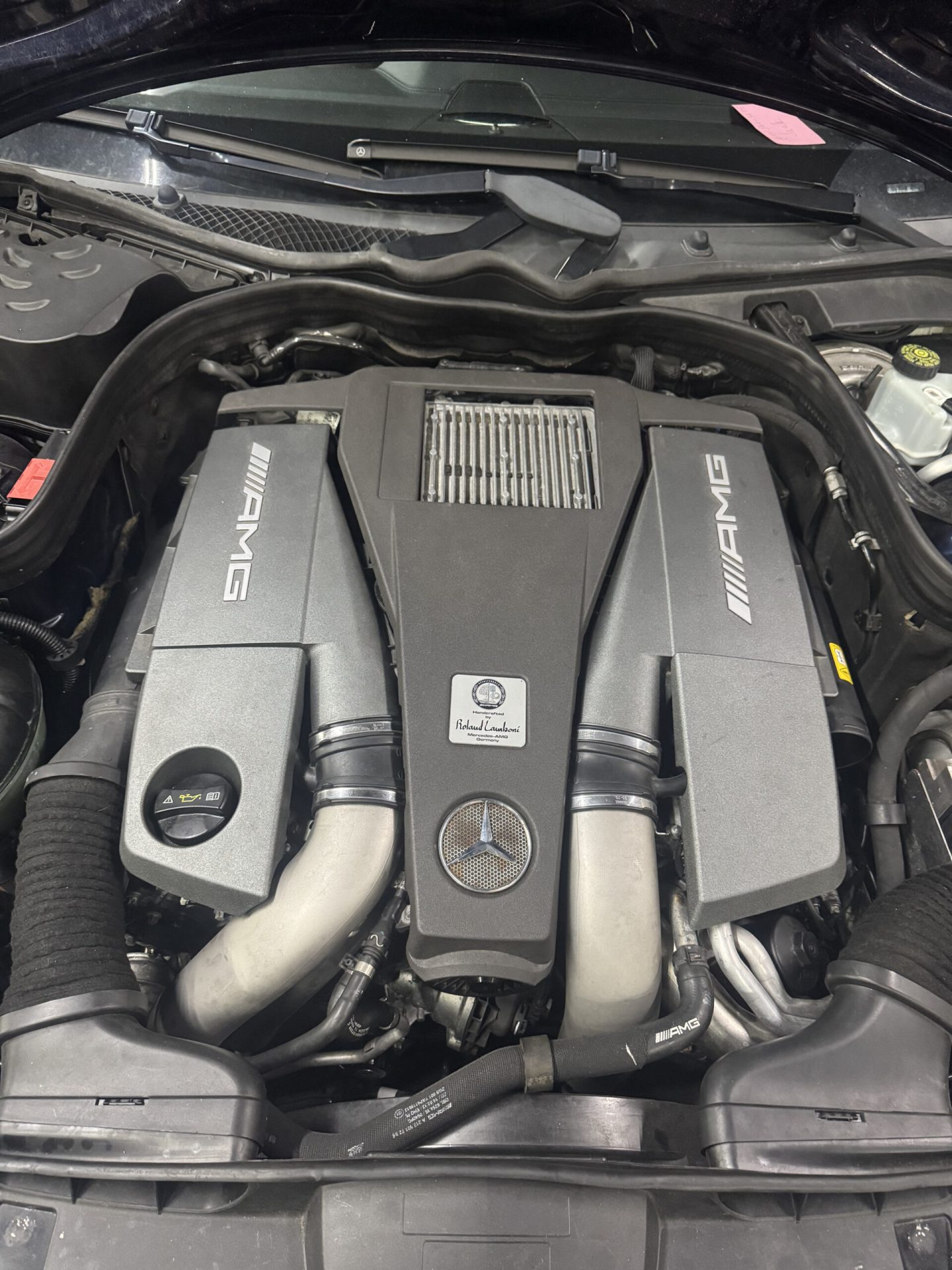 Mercedes-AMG 5.5L V8 biturbo engine with AMG covers and hand-built engine plaque at Philadelphia repair shop