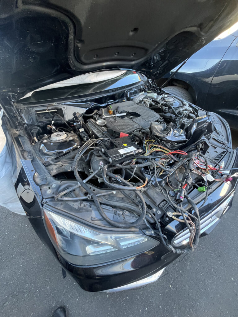 Mercedes-Benz C-Class with front bumper removed, exposing the engine bay and old wiring harness at TOP CONCEPT Philadelphia